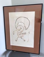 Framed artwork showing the squirrel print with brown matting and black frame, standing upright.