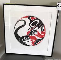 Front view of framed Indigenous art print featuring wolf in red, black and white with white matting and black frame. Frame shows some signs of needing cleaning.