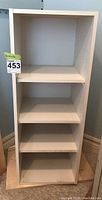 Front view of the white MDF shelf unit fully assembled with shelves.