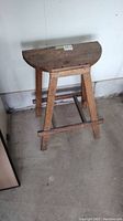 Full view of the vintage solid wood demilune stool showing its half-moon shape and overall condition.