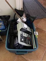 Photo showing the plastic tote with all contents including lamps, calculator, rulers, clips, and ribbon inside.