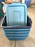 Stack of six blue Rubbermaid Roughneck storage totes stacked with five lids on top.