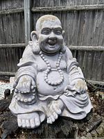 Front view showing the Buddha's smiling face, beaded necklace, and detailed robe folds.