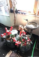 Plaster relief planters with faux red and pink flowers, bronze birdbath or planter with bird figurine, lion head garden sculpture