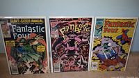 Full shot of three Fantastic Four comic books standing side-by-side showing covers of issues 20, 270, and 299 in varying condition.