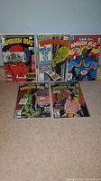 Five DC Ambush Bug comics laid out on floor, showing cover art and general condition.