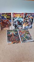Photo showing the five Suicide Squad comics, issues #13, 17, 25, 26, 27 laying flat on the floor.