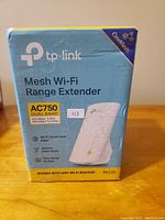 Front view of the TP-Link Mesh Wi-Fi Range Extender original box showing model and specifications.