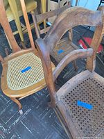 Two wooden chairs with cane woven seats and backs