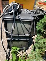 Photo of two Stromberg-Carlson CRT monitors outdoors, seen with multiple cables draped on top