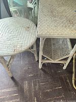 Image showing round wicker side table with rust stains and rectangular wicker magazine stand with woven open shelf underneath.