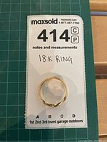 Overhead view of ring on lot card showing overall shape and marking