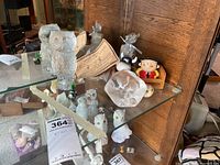 The entire collection displayed on a glass shelf including the large textured clear glass owl, smaller glass owls, leaf-shaped glass dish with owl impressions, and various small collectible figurines.