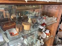 Wide view of wooden boxes, small statues, and glass items arranged on display shelves