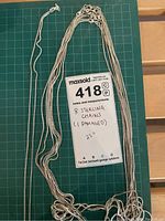 All eight chains laid out on cutting mat with Lot 418 tag showing count and length