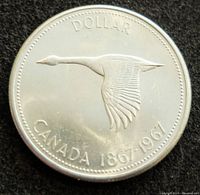 Obverse side showing flying Canada goose with text 'DOLLAR CANADA 1867-1967'