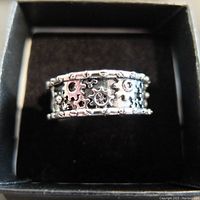 Top view of silver ring showing detailed mechanical gear design pattern on the band