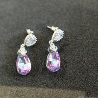 Pair of earrings with pear-shaped mystic topaz drops and round diamond type halo tops.