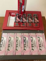 Photo showing multiple boxes of golf balls inside a red display tray including Lady E St. Andrews and DDH Lady brands.