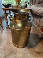 Side view showing the full large solid brass pot with two handles and embossed text on the side.