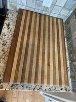Top view of one large wooden cutting board showing striped wood pattern on flat surface