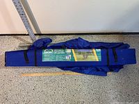 Folded blue Escort branded portable gazebo in carry bag with label