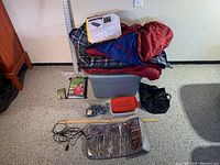 Full camping gear lot including sleeping bag, blankets, warmers, electric warming pad, storage containers.