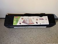 Packed tent in black carry bag showing Coleman label