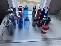 Photo showing 24 assorted water bottles including Contigo, plastic, metal, and insulated coffee mug