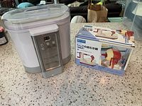 Cuisinart yogurt machine next to boxed apple peeler on countertop