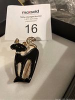 Front view of black cat brooch highlighting rhinestone details on ears, collar, and tail.
