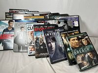 Photo showing front covers of DVDs in a line, titles visible such as Abduction, Casino, Stop-Loss, The Invisible, The Breach.