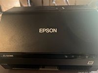 Top view of the black Epson ES-500WR scanner with Epson logo visible.
