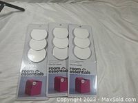 Three packs of Room Essentials clip-on dry erase fabric bin labels, each containing 3 white oval labels in packaging placed on a light fabric surface.