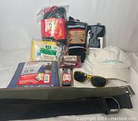 Full overall photo of the 18-piece men's accessories bundle showing belts, multiple pairs of socks, bow tie, shoe laces, rain poncho, hat, and sunglasses.