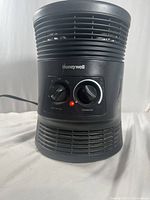 Front view of black Honeywell portable heater showing two control knobs and red indicator light.