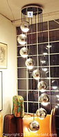 Chrome mid-century hanging lamp installed in window display, showing chrome canopy and sphere pendants suspended