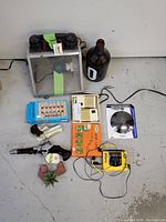 Miscellaneous lot including handmade phone lamp, glass growler, xylophone, electronics, and more on concrete floor