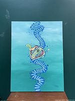 Front view of the original painting showing abstract organic and rib-like shapes in blue, yellow, and multi-colors on a greenish background, hung on a dark green wall.