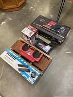 Lot contents including floor jack, jack stands boxes, breaker bars, snow chains, kneeling creeper, vintage creeper, and ramps.