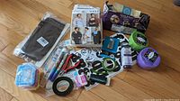 Photo showing a variety of party and craft supplies including sewing patterns, decorative tape rolls, markers, adhesive letters and numbers, pliers, small plastic boxes, and candle making supplies.