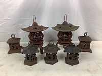 Front view of all seven pagoda-style lanterns showing variety of shapes and sizes