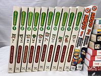 Photo of Yotsuba&! manga volumes 1-12, Naruto volumes 1 and 2 manga spines, neatly lined showing titles and volume numbers.
