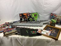 Overview of partially assembled Super Star Destroyer hull, retail boxes, instruction manuals and framed poster on table