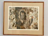 Framed lithograph showing owl and woodpecker on tree with leaves in soft brown and gray tones.