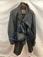 Full view of First Gear jacket and motorcycle gear hanging on a hanger showing overall condition and items included