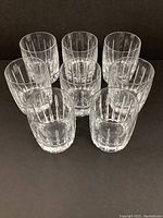 Eight clear crystal old fashioned glasses arranged in two rows to show detail and facets