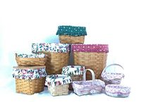 Group of 10 hand-woven baskets in various sizes with different floral fabric liners shown on white background.