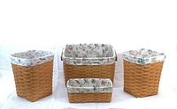 Four Longaberger hand woven baskets with light wood tone and floral 'Botanical Fields' liners visible inside.