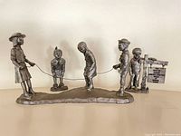 Full view of the jumping rope pewter sculpture depicting five children playing.